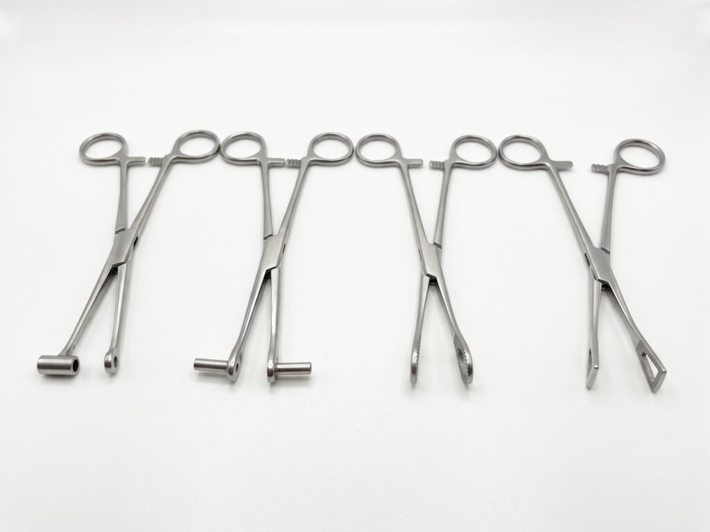 Pinze per body piercing con diverse forme delle estremità, disposte su fondo bianco.